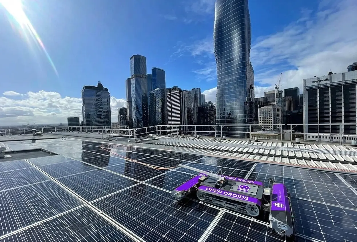 Corporate office park with sleek mower working, person reading on bench nearby undisturbed